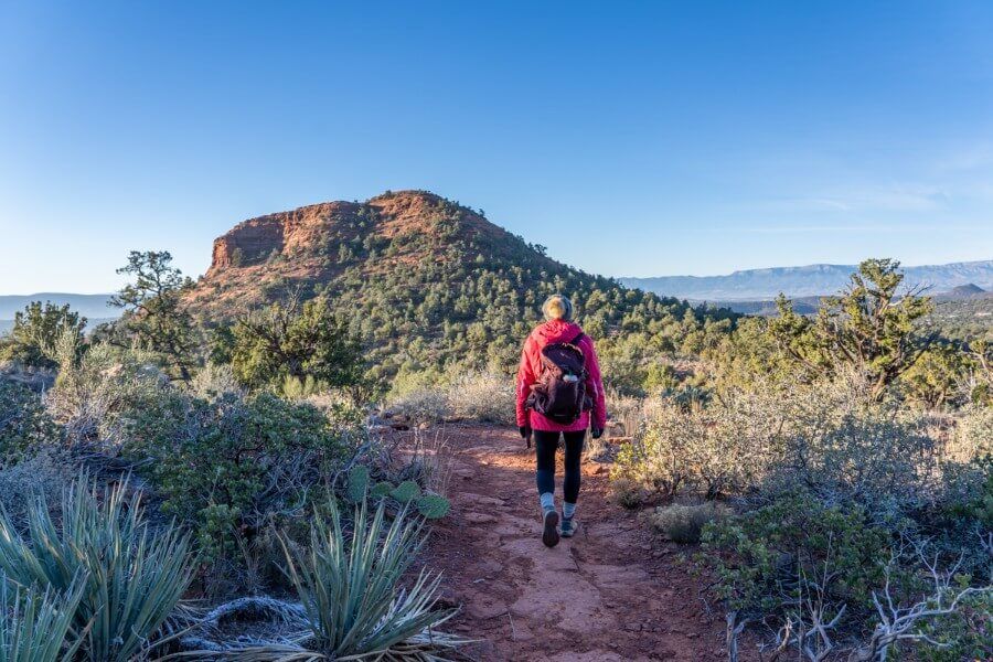 Hiking a dirt path at dawn in Arizona sunlight and shadows