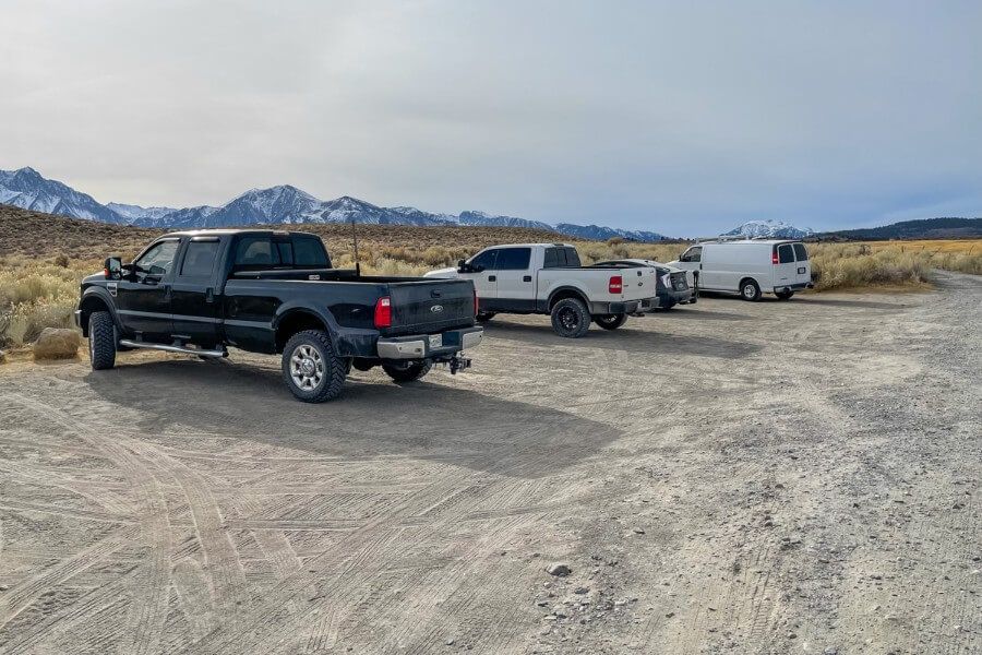 Four vehicles parked along a dirt road in a remote part of California