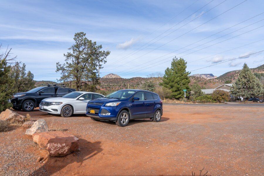 Pyramid Loop Trail parking lot on Red Rock Road in Sedona Arizona with three cars in gravel lot