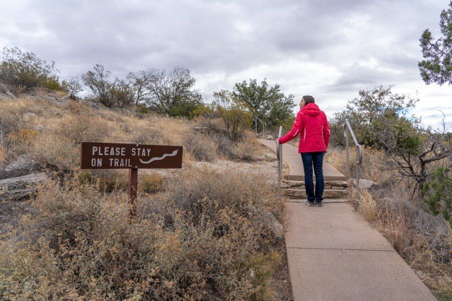 A woman walking up a small hill to Montezuma Well