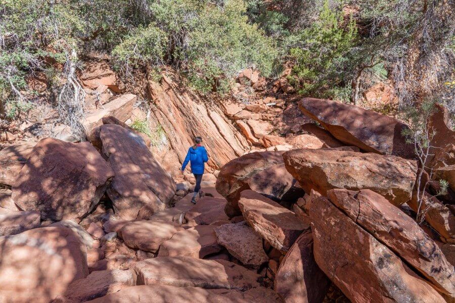 Woman walking over rocks along a hiking trail
