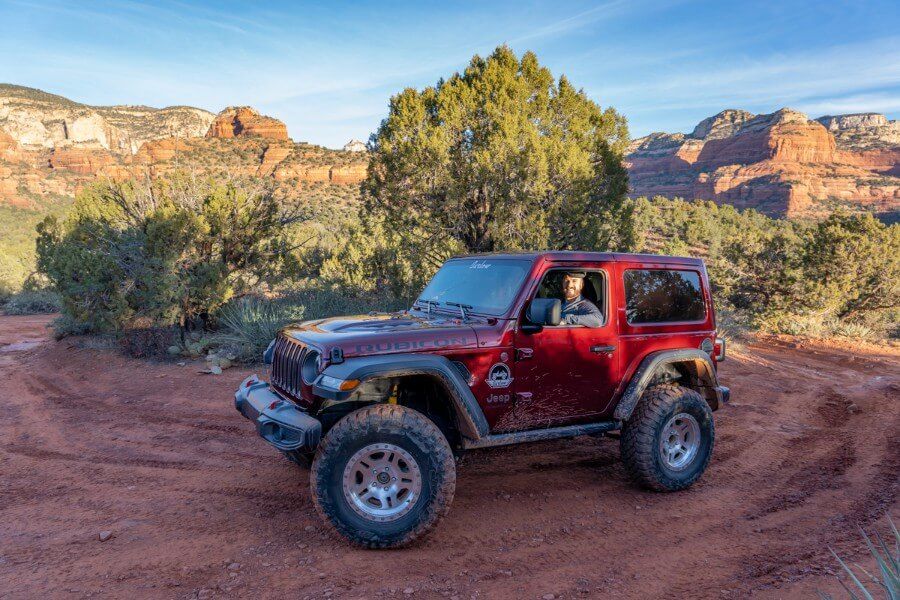 Red Jeep Rubicon parked at the end of Mystic Vista off road trail in Sedona Arizona at sunrise
