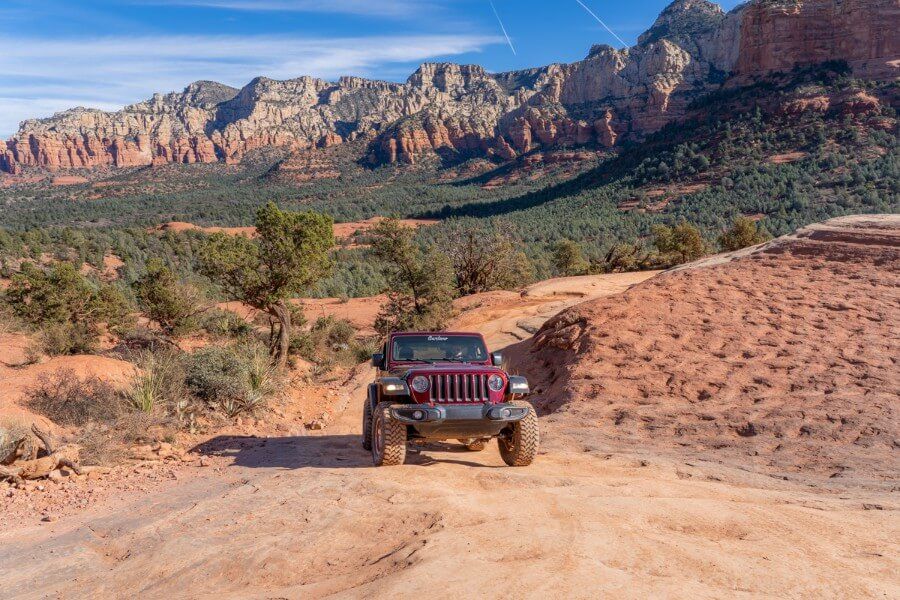 Front on photo of a Wrangler driving on red rocks in Arizona