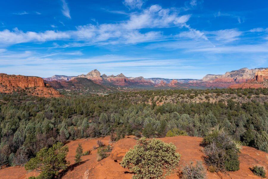 View over Sedona from Submarine Rock vista with blue sky red rocks and green desert vegetation