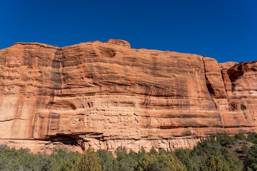 Red rock canyon walls with green trees