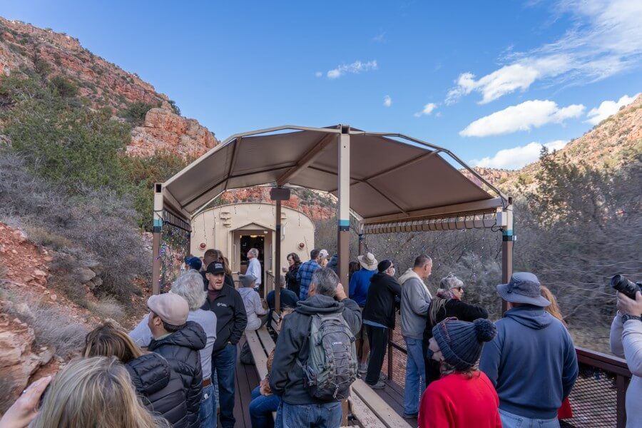 Passengers observing the Verde Canyon in an open air viewing car