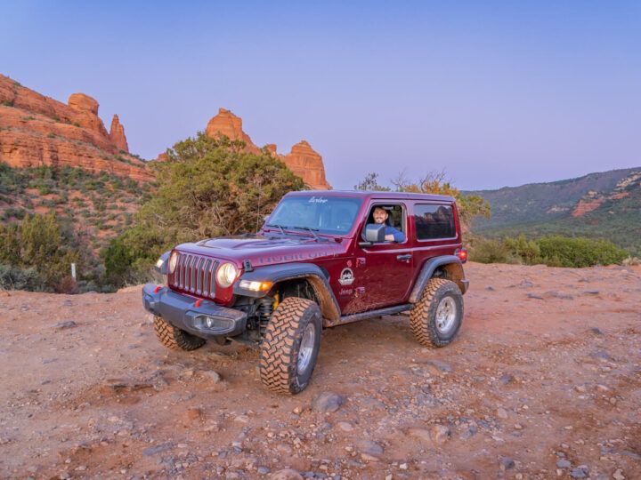Driving off road 4WD Jeep on Schnebly Hill Road Trail at dusk with purple sky right after sunset in Sedona Arizona