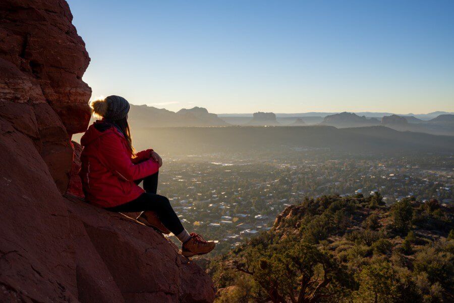 Hiker watching sunrise over Sedona AZ on a cold but sunny Winter morning in December