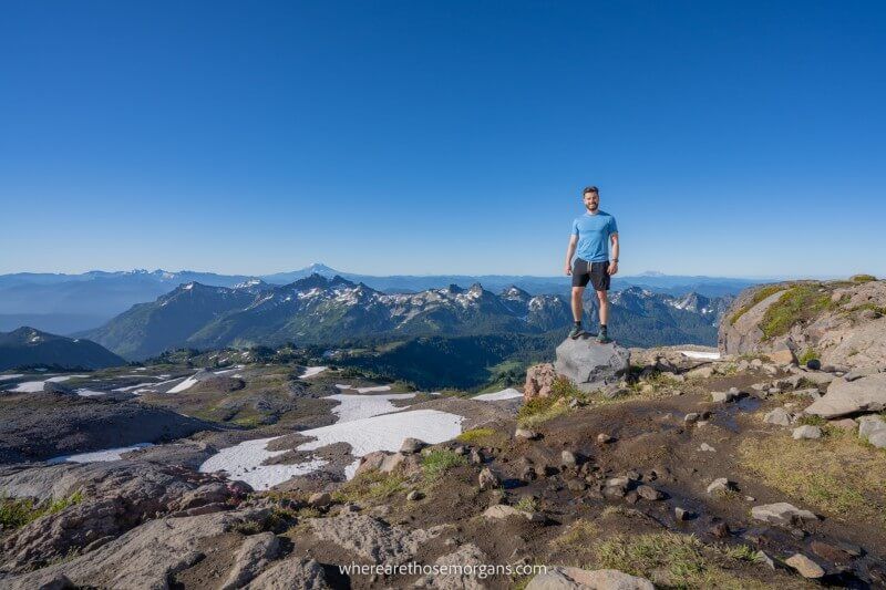 Hiker stood on a rock at the summit of Skyline Trail one of the best hikes in Washington and the US