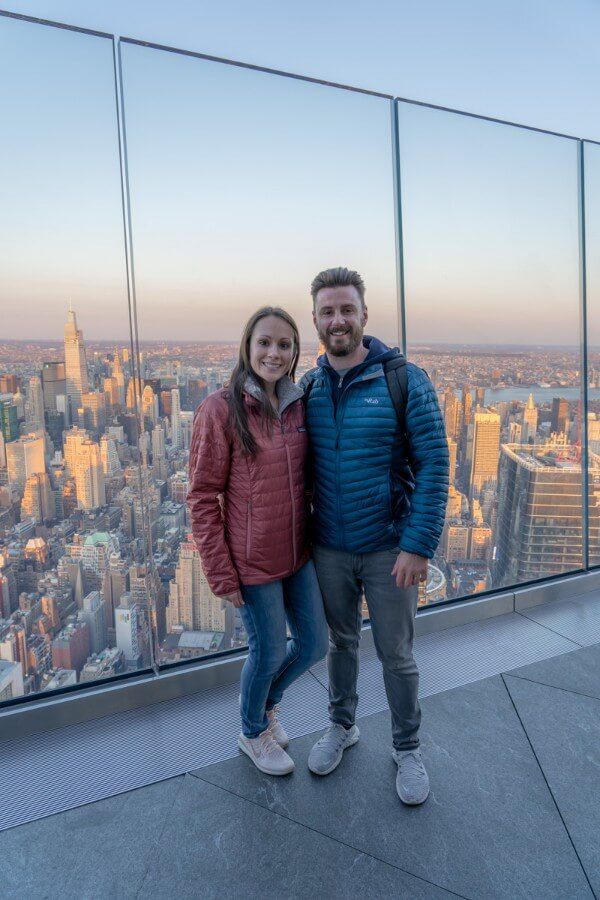 Woman and man posing for a picture on the outdoor viewing platform in New York City