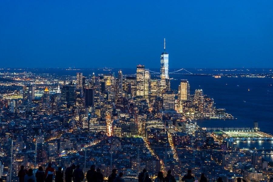 Close up view of One World Observatory and the Lower Manhattan skyline lit up at night