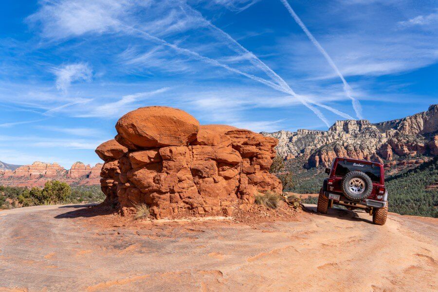 Driving a Jeep rubicon around a mushroom shaped rock on broken arrow trail