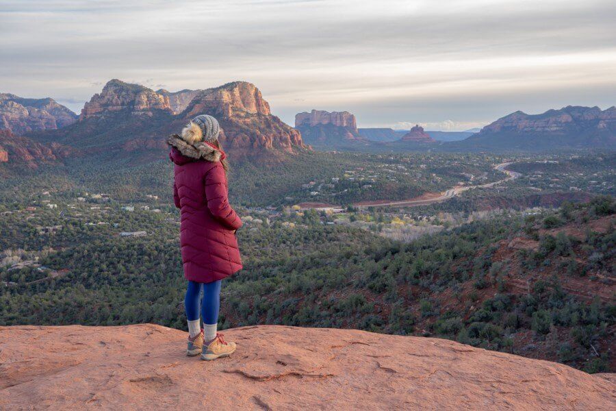 Hiker wearing fur coat at a vista in Sedona during a winter itinerary visit