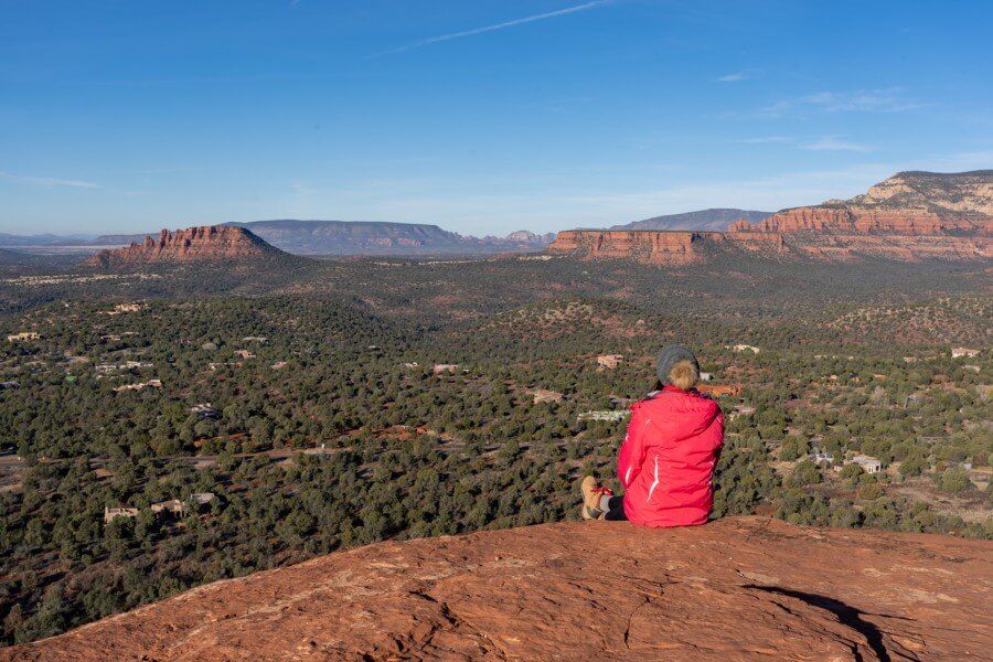 Hiker watching sunrise over Sedona from the summit of Little Sugarloaf