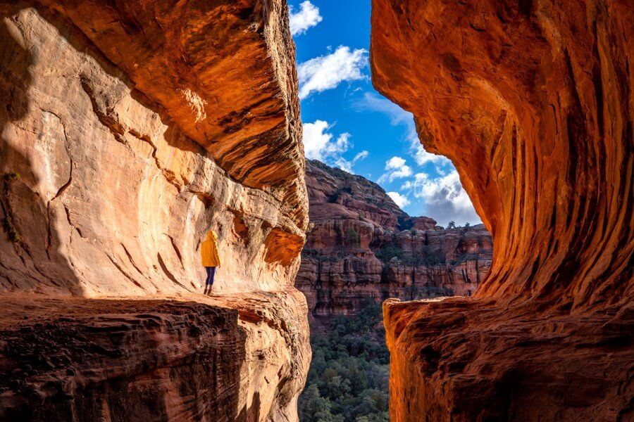 Boynton Canyon cave with a woman standing in a yellow raincoat