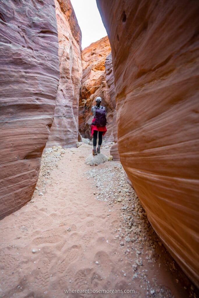 Hiker walking through narrow Buckskin Gulch slot canyon in Utah one of the top outdoorsy things to do UT
