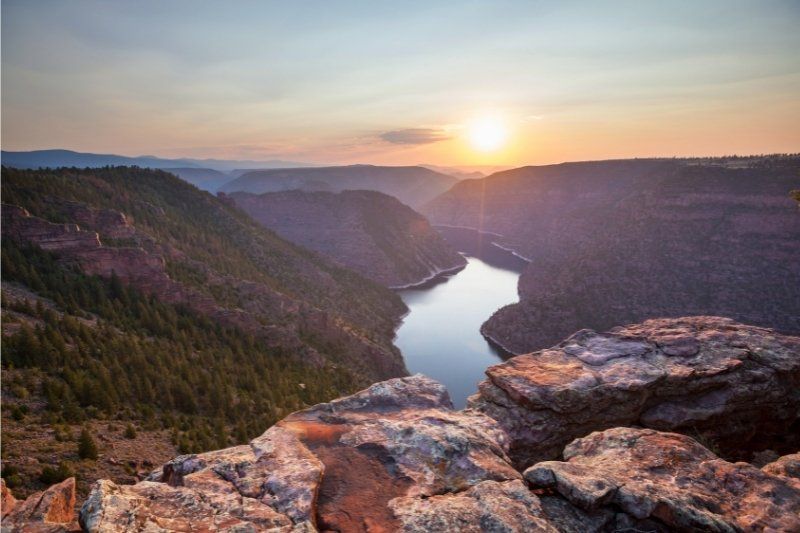 Sunset at Flaming Gorge on the border between Utah and Wyoming stunning gorge with river and rocks in foreground