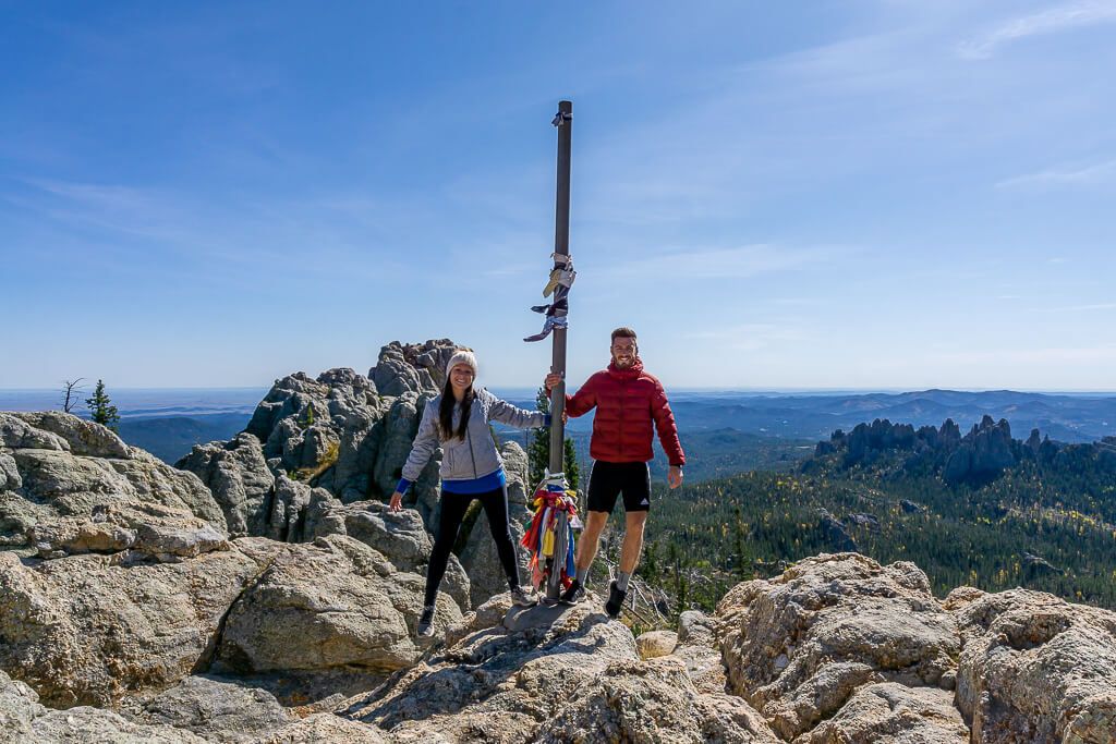 Two people standing at the top of Black Elk Peak in South Dakota
