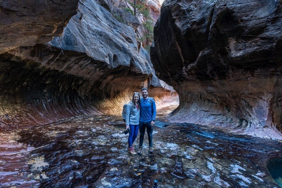 Man and woman posing for a photo in the Subway at Zion National Park in Utah