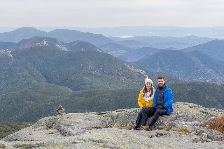 Woman and man enjoying the view from the Mount Marcy Summit in Upstate New York