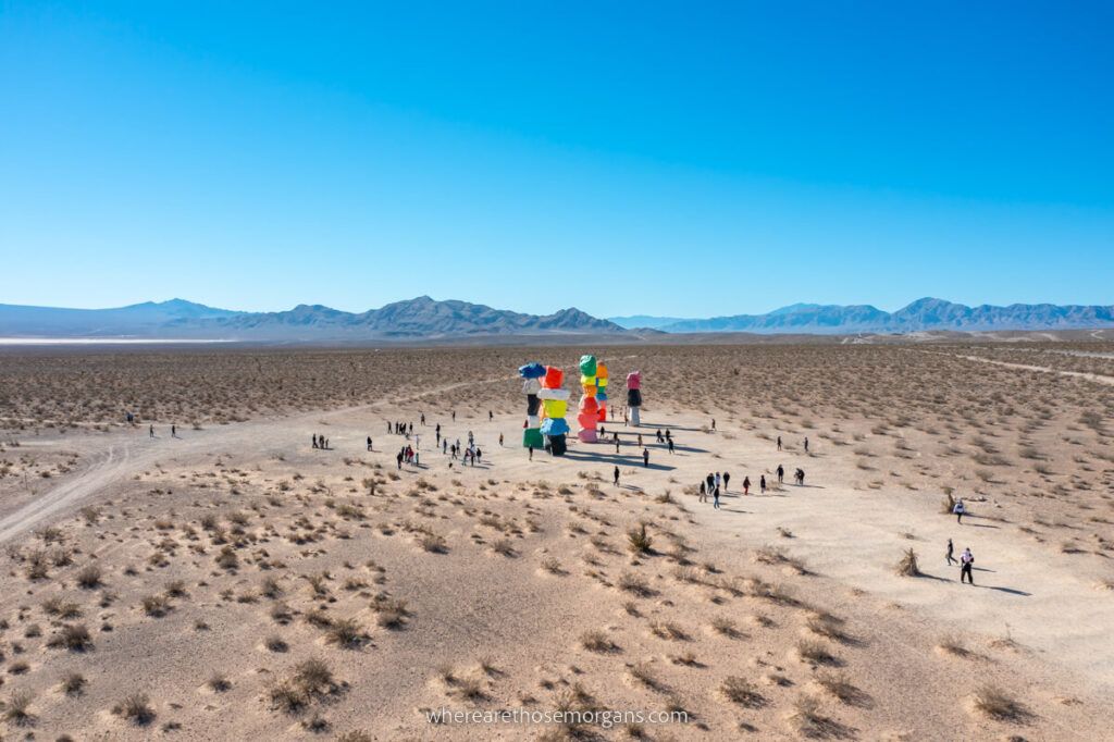 Drone photo of art installation in the desert with people walking to and from the exhibit