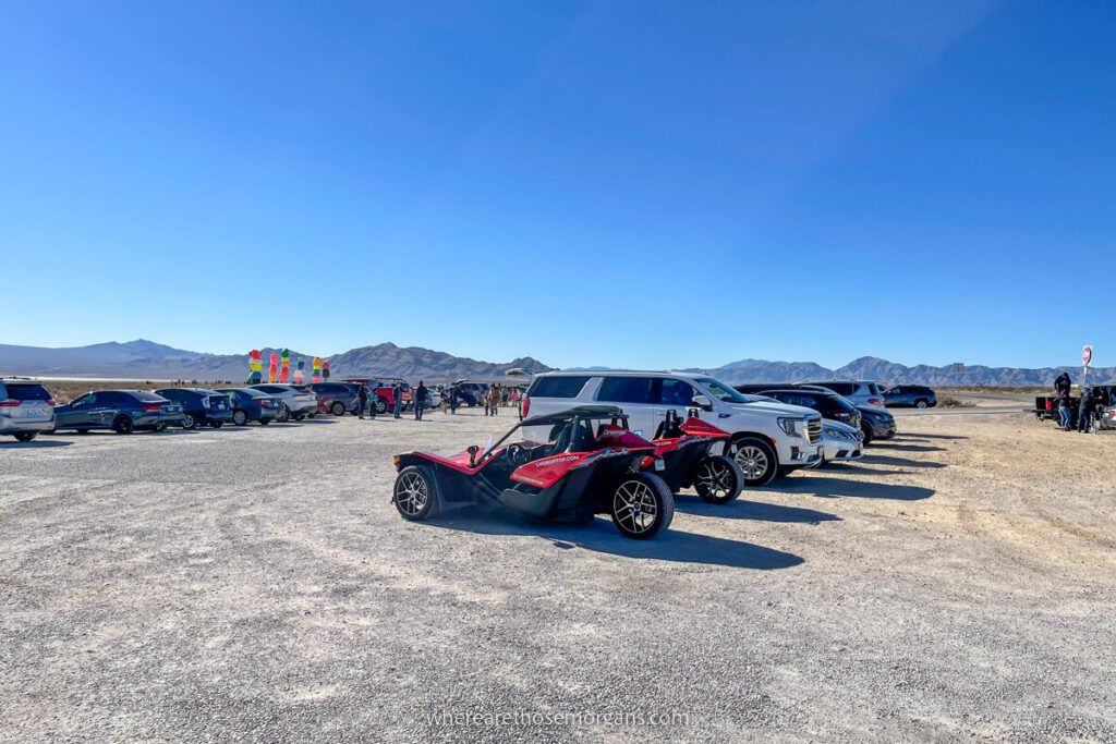 Parking lot on gravel with cars and ATV's filling the spaces
