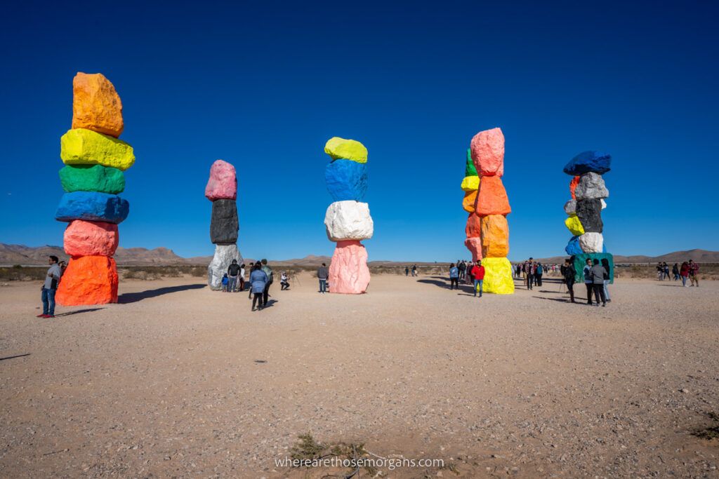 Tourists taking selfies with colorful boulder stacks in the Mojave desert