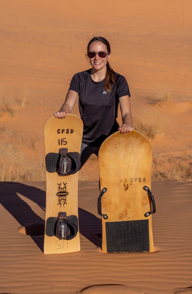 Woman at Coral Pink Sand Dunes State Park with rent sled and board