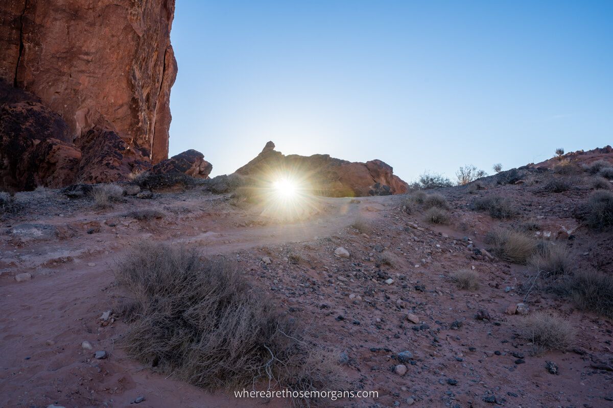 Gravel path with rocks and sun bursting through small arch