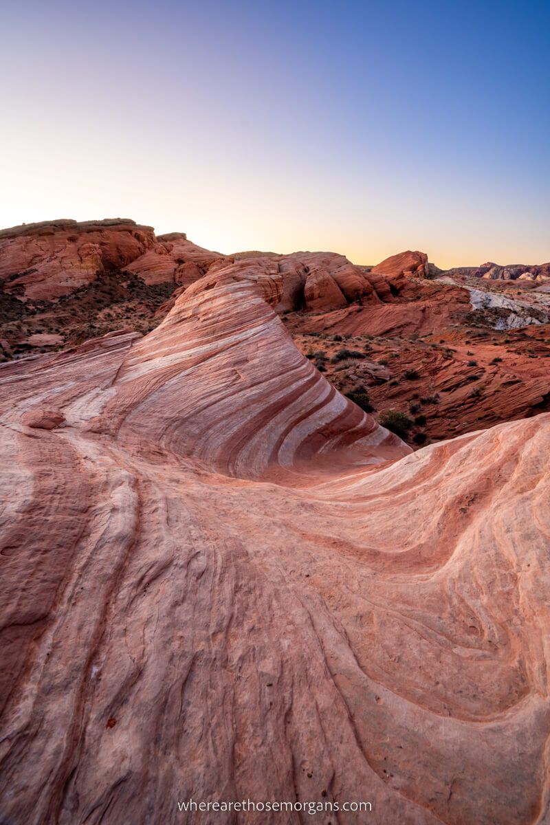 Soft and serene red and white layers of sandstone rocks merging around dome rocks like waves at sunrise at the Fire Wave near Las Vegas
