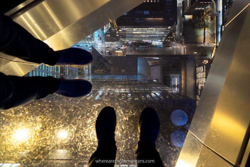 Woman and man standing on glass floor of Edge observation deck