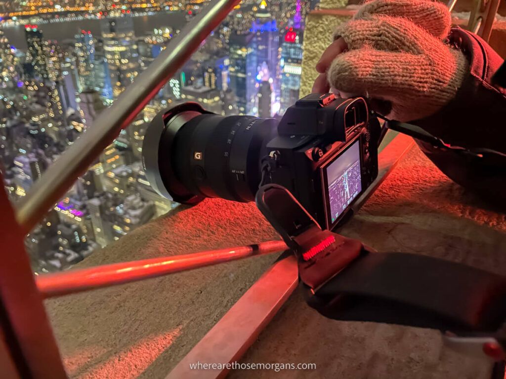 Man focusing a camera to take a photo at the Empire State Building