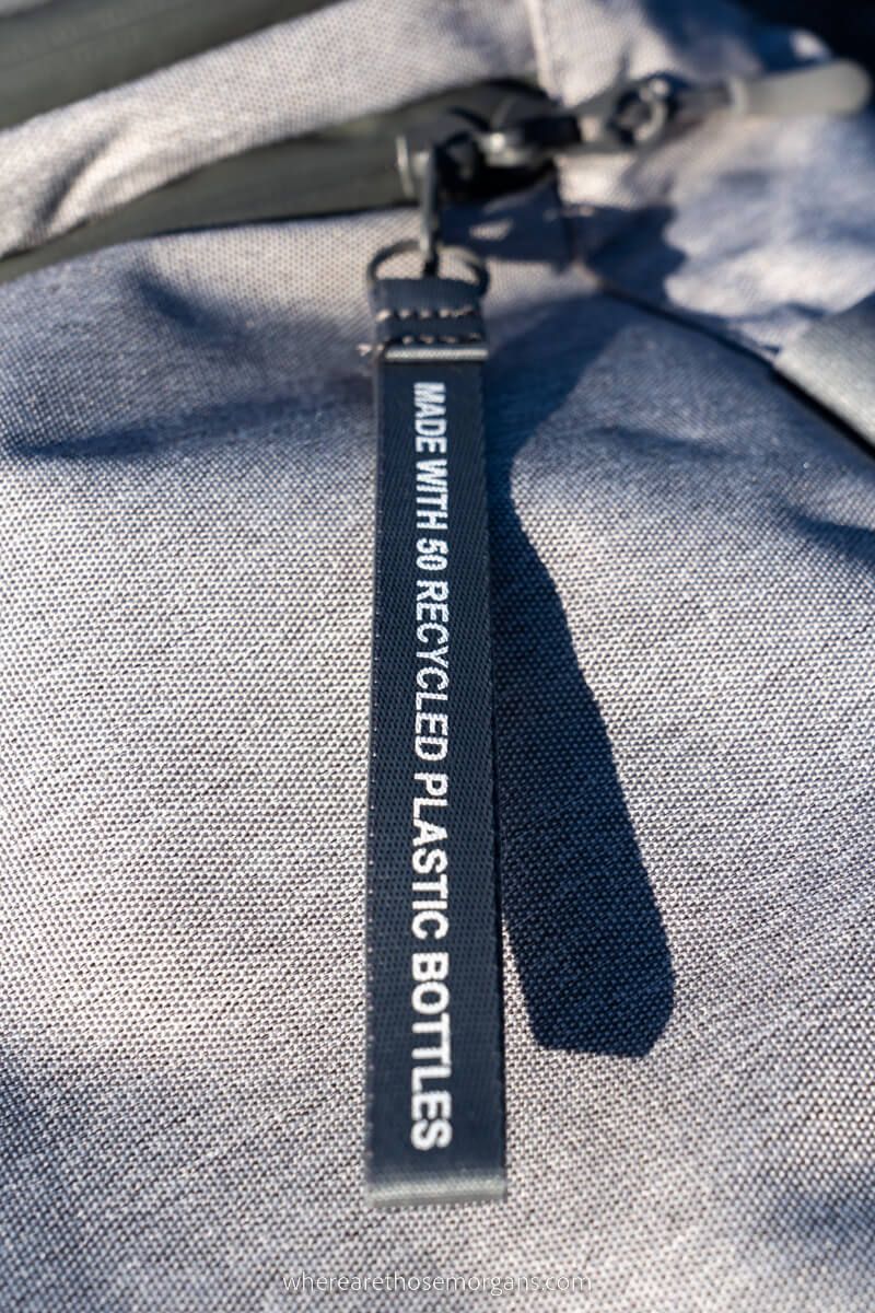 Close view of a zipper with a sign indicating this bag was made from 50 recycled bottles