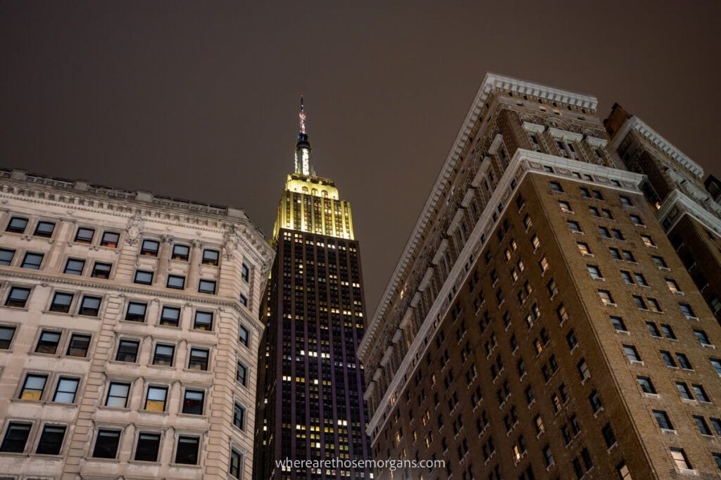 Manhattan street view of Empire State Building lit up at night