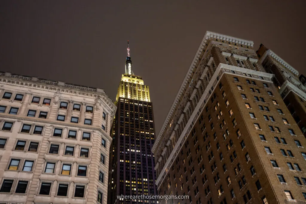 Manhattan street view of Empire State Building lit up at night