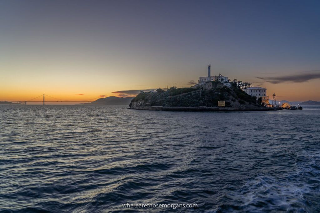 Night shot of Alcatraz Island with sun setting behind the Golden Gate Bridge