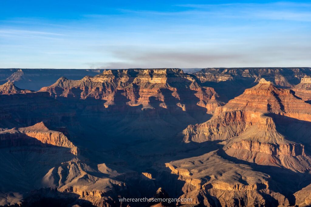 Grand Canyon South Rim in late afternoon with deep shadows and soft yellow sunlight contrasting on a day trip from Las Vegas