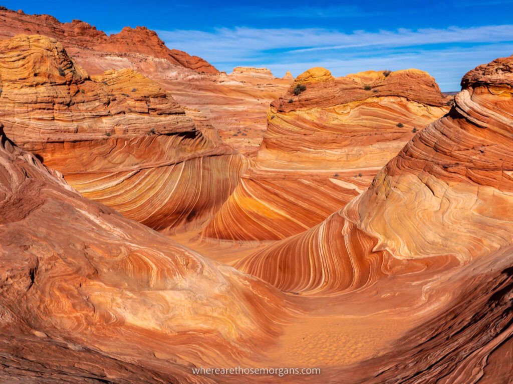 The Wave in Arizona incredibly photogenic landscape filled with swirling red and orange layered sandstone patters swirling around mounds