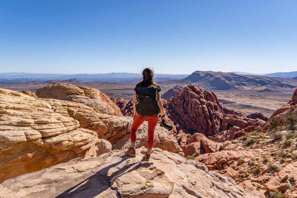 Hiker stood on a summit in Red Rock Canyon one of the easiest day trips from Las Vegas desert landscape background