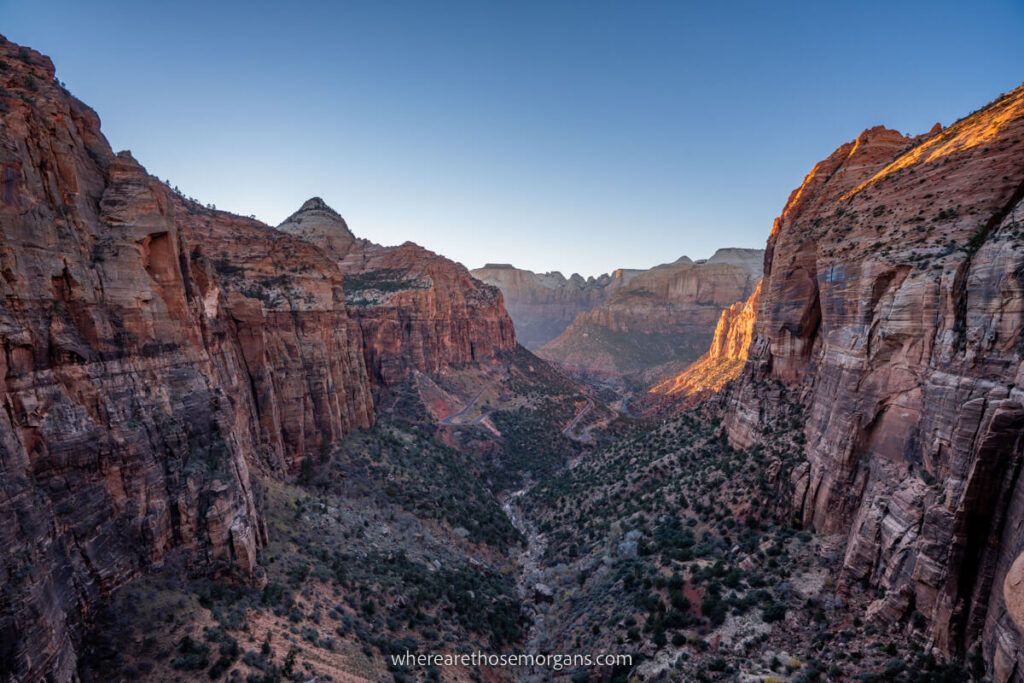 Zion Canyon Overlook towering canyon walls to either side of a flat valley floor with soft light at dusk one of the most popular day trips from Las Vegas