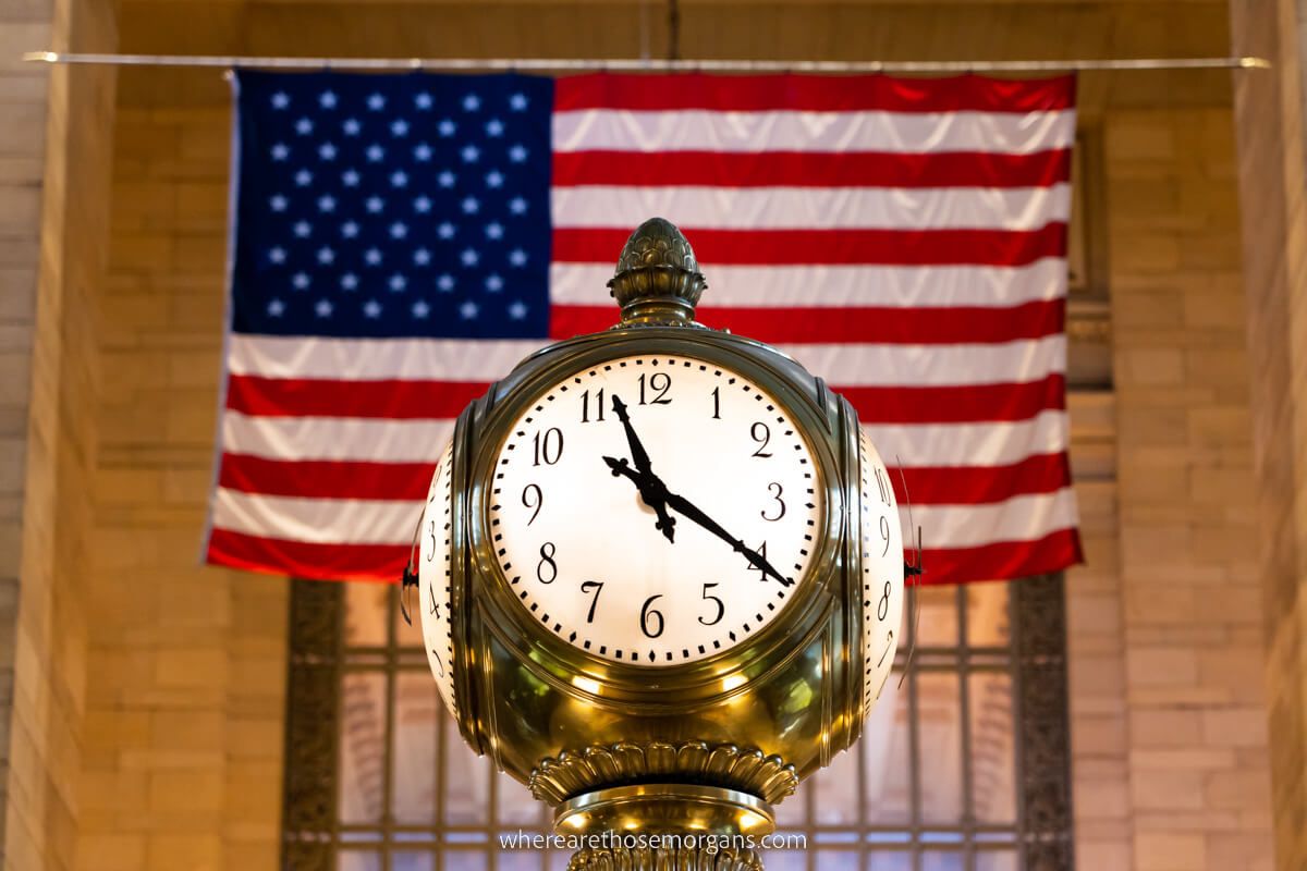 Famous four sided clock in Grand Central backed by the US flag