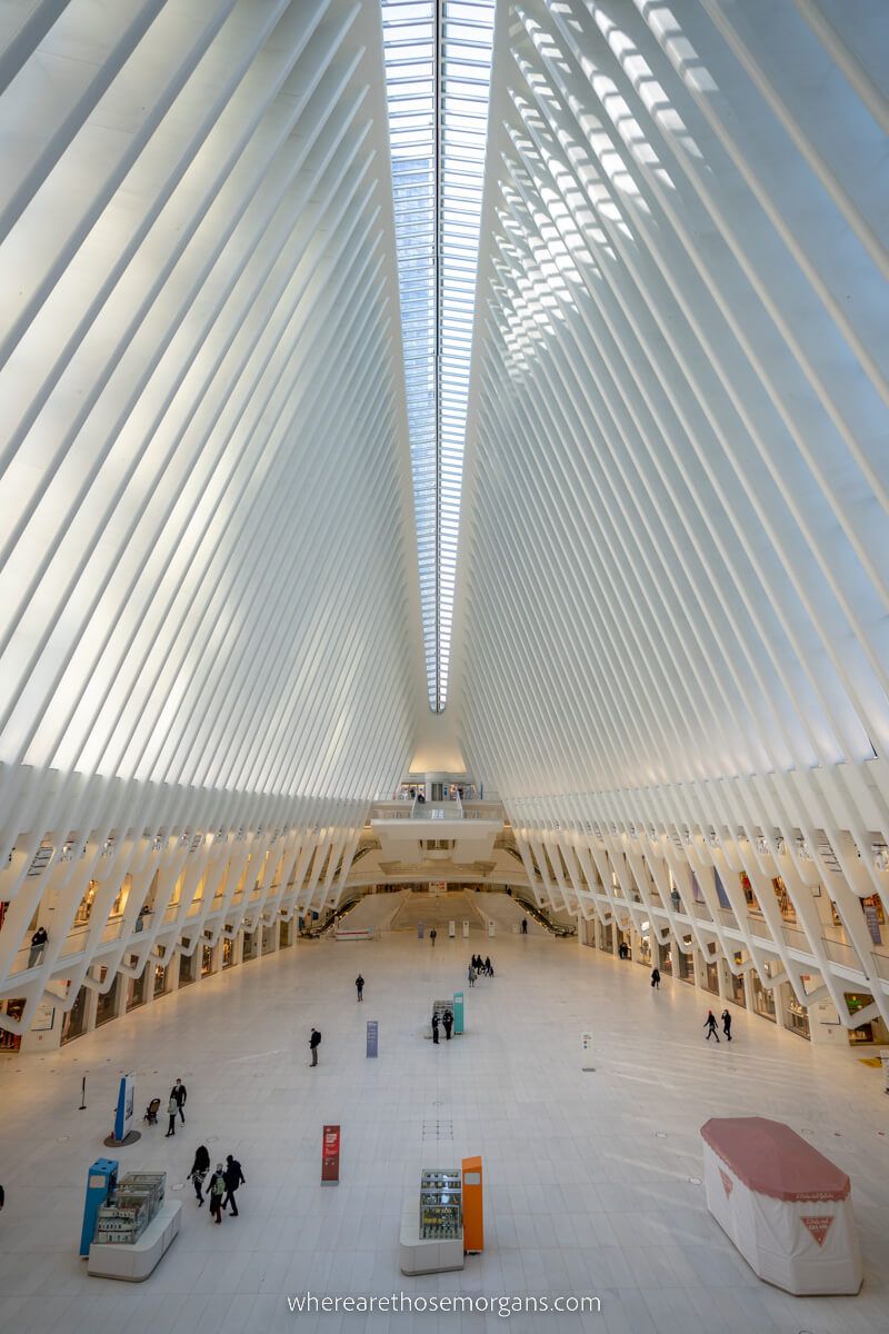 Inside Oculus brilliant white architecture with stands and people walking below