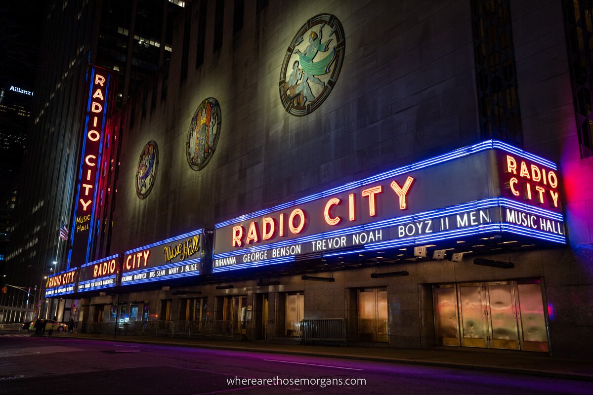 Radio City music hall lit up at night against the dark sky in New York City