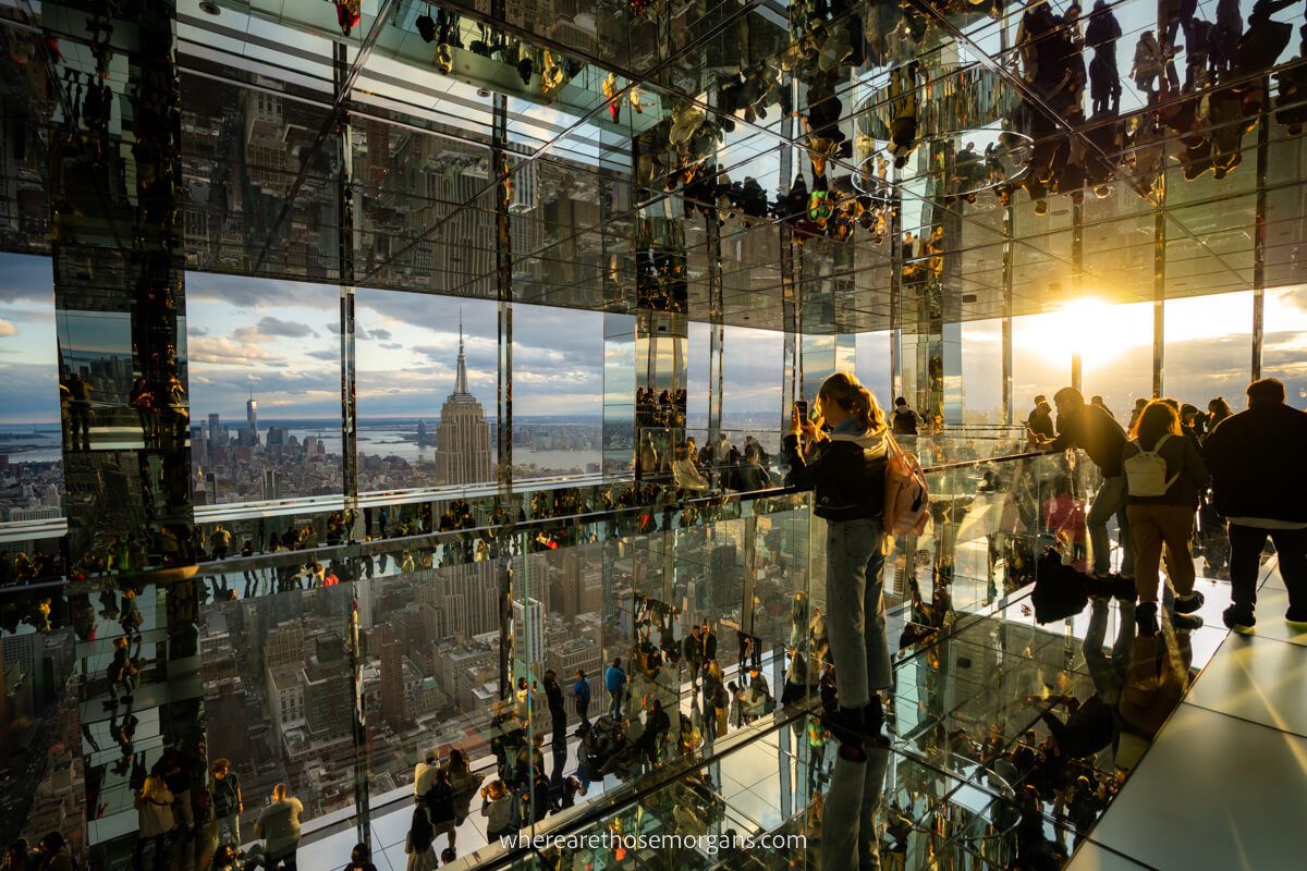 Stunning sunset beaming through glass windows at the top of summit one vanderbilt observation deck with views of empire state one of the best things to do in nyc