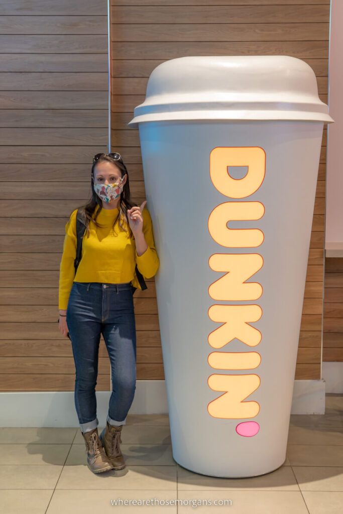 Woman stood next to life size dunkin donuts coffee cup