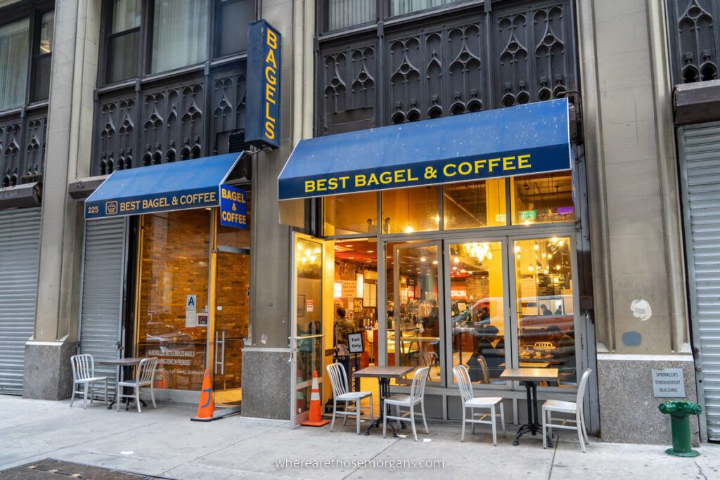 Best Bagels and Coffee breakfast bagel joint in New York City in April on a cold morning lights on inside chairs and tables on sidewalk outside