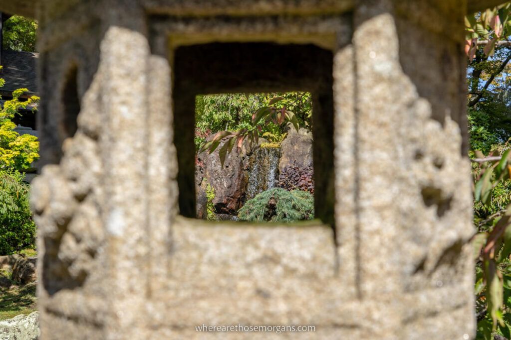 Photo of a small waterfall framed in a photo with a stone lantern