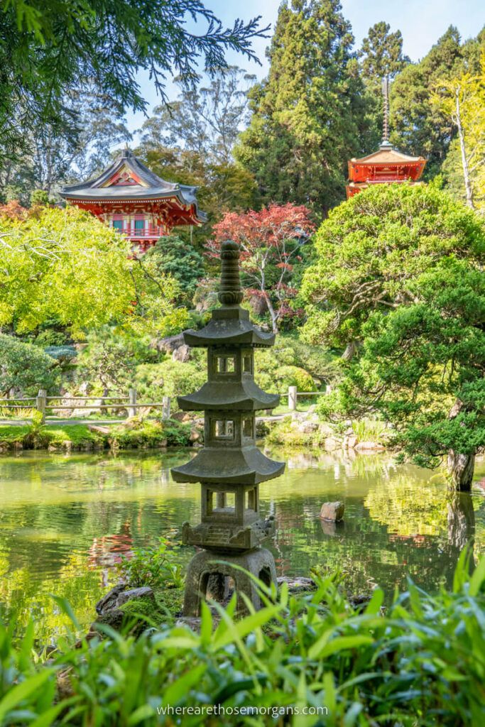 Four tiered lantern next to a pond with two red pagodas