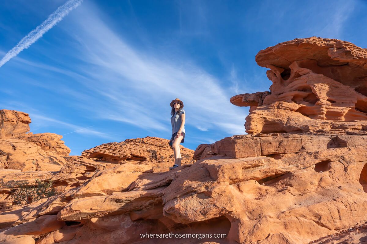 Hiker stood on The Beehives rock formation in Valley of Fire State Park with a hat on a sunny day