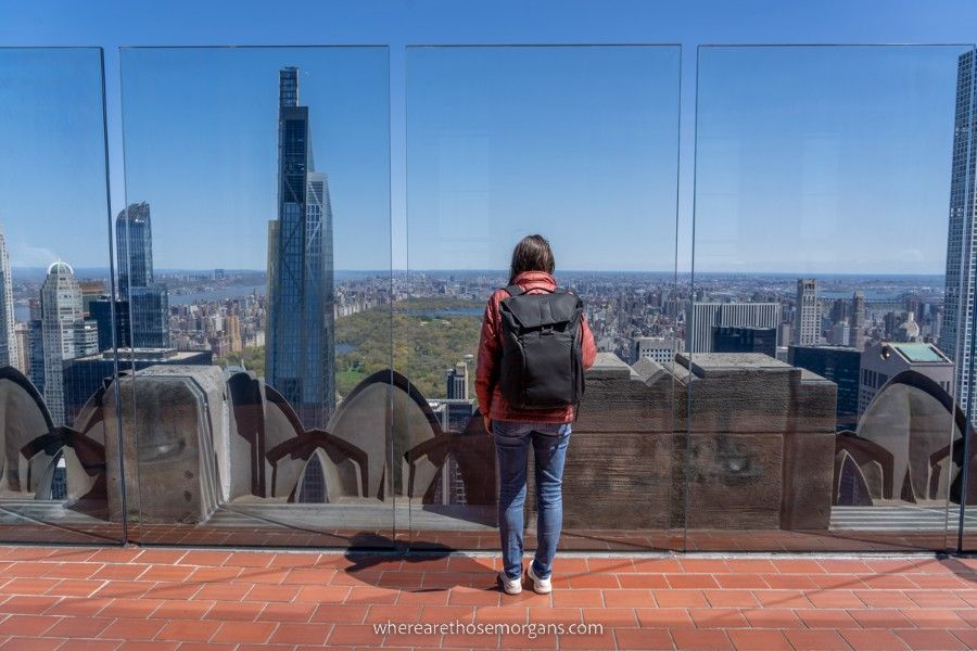 Woman looking through glass panels at Top of the Rock observation deck